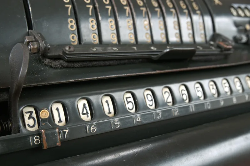 Calcolatrice vintage con simboli matematici — storia dell'invenzione